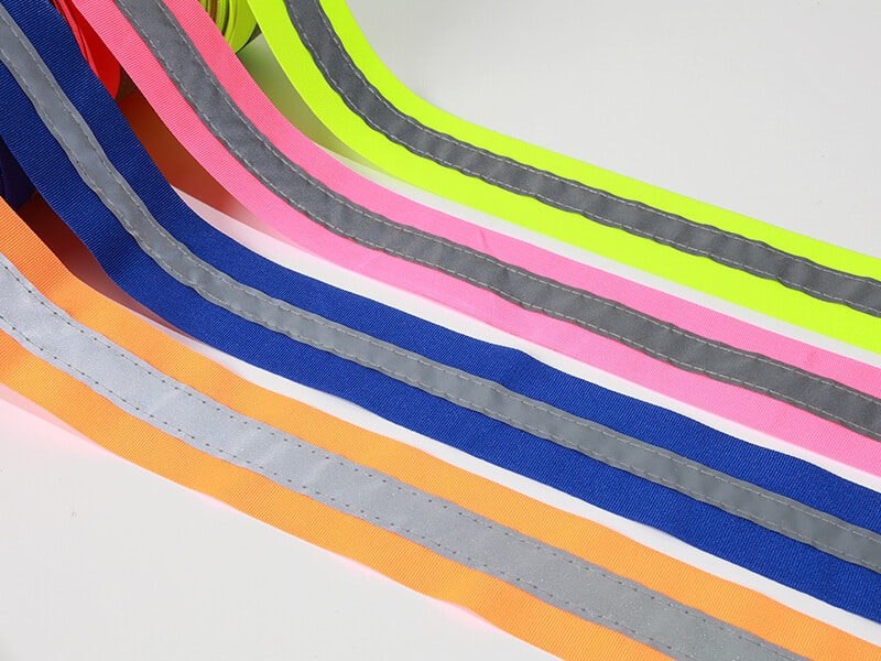 Colored webbing tapes with stitched silver reflective strips down the center.