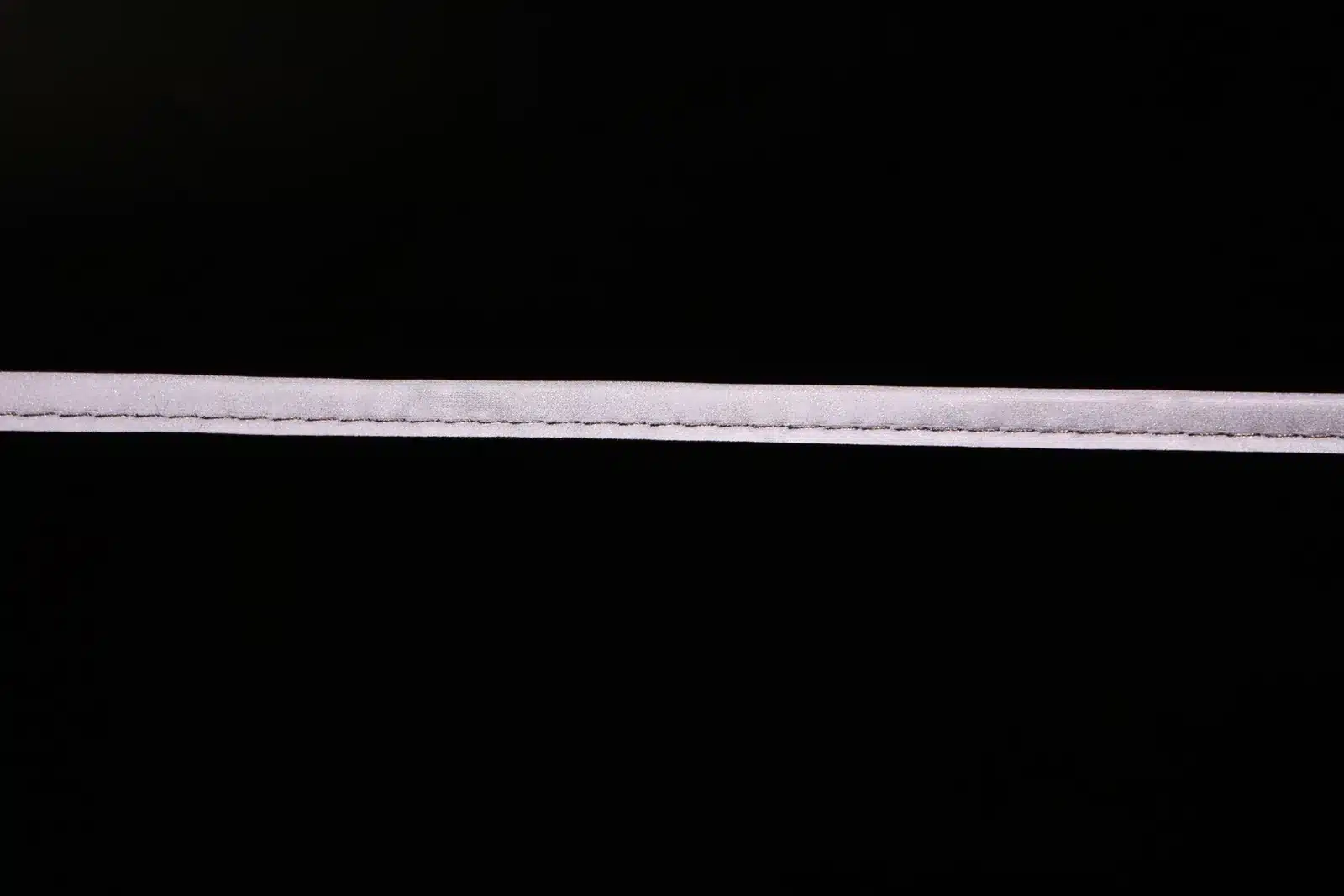Close view of an MP0104 piping strip and its stitch line on a dark background