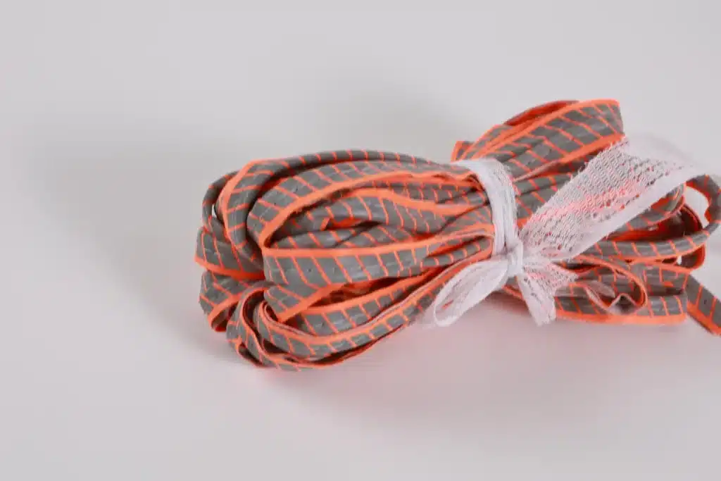 Bundle of gray patterned piping with orange edging and a white tie