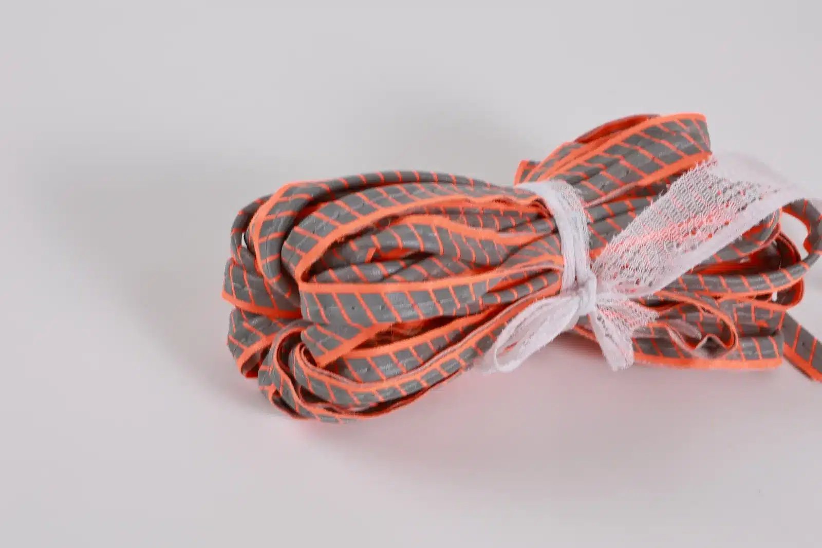 Bundle of gray patterned piping with orange edging and a white tie
